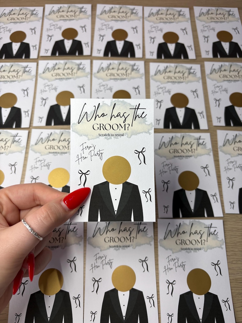 May include: A rectangular white card featuring the text Who has the GROOM? Scratch to reveal and Fern's Hen Party. The card displays a graphic of a tuxedo with a circular gold scratch-off sticker as the head and small black bow illustrations.