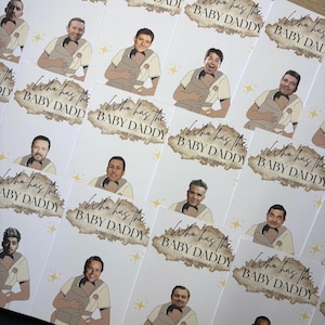 May include: Cards with illustrations of various celebrities holding babies in carriers. Each card has the text "Who has the BABY DADDY" with a scratch-off area. The cards are white with a brown and gold design.