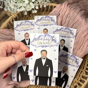 May include: A set of rectangular scratch-off game cards featuring the text Who has the GROOM? Scratch to reveal. Each card displays a different man in a black tuxedo and bowtie, accented with small light purple hearts and a watercolour-style purple header.