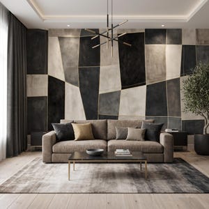 May include: A beige sofa with dark gray and tan throw pillows sits before a wall featuring a large-scale geometric mural in shades of black, gray, and white. A rectangular coffee table with a dark top and gold legs is placed on a gray area rug.