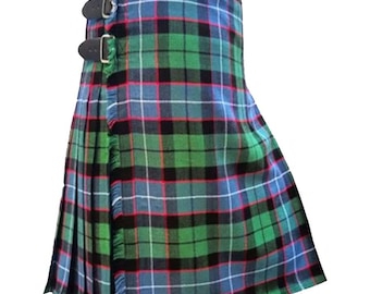 Op de afbeelding: Een groene, blauwe en rode tartan kilt met zwarte accenten en een gefranst randje. De kilt heeft twee gespen aan de zijkant.