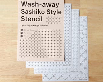 May include: A set of three rectangular wash-away Sashiko style stencils. The top sheet is light peach with black text reading Wash-away Sashiko Style Stencil, Upcycling through tradition, and lists Classic Crosses, Persimmon, and Waves patterns.