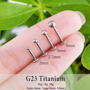 Peut inclure: Quatre bijoux de piercing labret en titane G23 de couleur argentée avec des embouts sphériques, classés par taille. Les diamètres des billes sont indiqués : 2mm, 2,5mm, 3mm et 4mm. Le texte indique Titane G23, calibres 16g, 18g, 20g et longueurs 5mm à 10mm.
