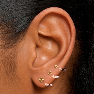May include: Three gold-toned stud earrings shaped like small flowers, each composed of tiny spheres. The earrings are labeled with their respective sizes: 3mm, 4mm, and 5mm, indicating the diameter of each individual flower-shaped stud earring.