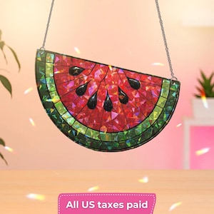 May include: A stained glass watermelon slice with a mosaic design. The red interior features black seed accents, while the rind is green and yellow. The artwork hangs from a silver chain.