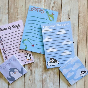 May include: Four different notepads with penguin illustrations and lined paper. The notepads have the titles "Waddle of things", "Notes", "Floating Thoughts", and "Head in the clouds".