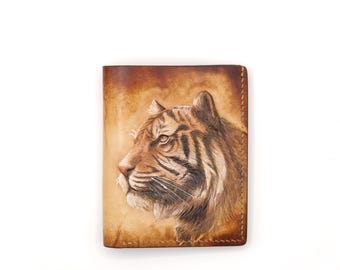 May include: A brown leather wallet with a detailed illustration of a tiger's face.