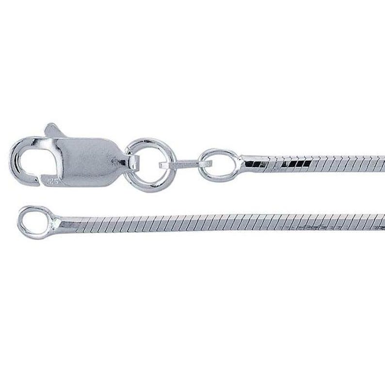 May include: A silver-colored snake chain necklace with a lobster clasp closure. The chain is made of small, interconnected links that create a smooth, flexible texture. The clasp and end ring are also silver-toned.