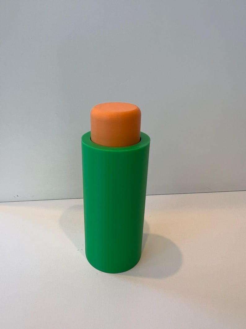 Pu&ograve; includere: Un tappo per bottiglia cilindrico verde e arancione. La parte superiore del tappo &egrave; arancione e la parte inferiore &egrave; verde.