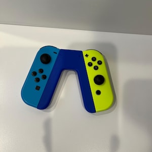 Puede incluir: Un mando Nintendo Switch Joy-Con azul y amarillo con botones negros.