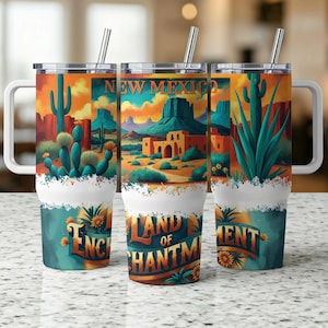 May include: Three stainless steel travel mugs with white handles and lids. Each mug features a colorful Southwestern landscape design with cacti, mountains, and the text "NEW MEXICO" and "LAND OF ENCHANTMENT". The mugs have a white base and a teal and orange floral design.