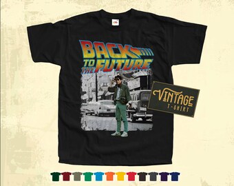 May include: Black t-shirt with a vintage "Back to the Future" graphic featuring a character from the movie. The graphic includes the movie title and a scene from the film. The t-shirt has a vintage t-shirt label.