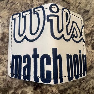 Könnte beinhalten: Weiße Ledergeldbörse mit blauen Nähten und dem aufgedruckten Text "Wilson match point" auf der Vorderseite.