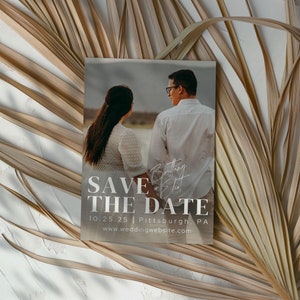 May include: Save the date card with a photo of a couple in front of a beach. The text on the card reads "Save the Date" with the date "10.25.25" and location "Pittsburgh, PA". The website address "www.weddingwebsite.com" is also included.