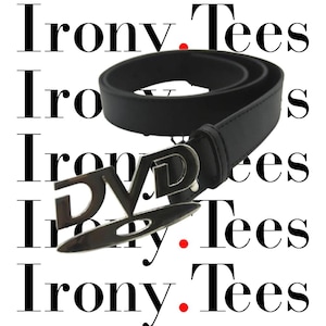 Könnte beinhalten: Schwarzer Gürtel mit einer silberfarbenen Schnalle mit der Aufschrift "DVD". Der Gürtel besteht aus einem glatten, einfarbigen schwarzen Material. Der Hintergrund zeigt die Worte "Irony Tees" in einem sich wiederholenden Muster.