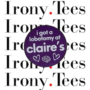 May include: Purple button with white text that reads "i got a lobotomy at claire's". The button has two white hearts and a white brain graphic. The button is in front of the text "irony. tees" repeated five times.