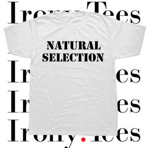 May include: White t-shirt with the text "NATURAL SELECTION" printed in black.