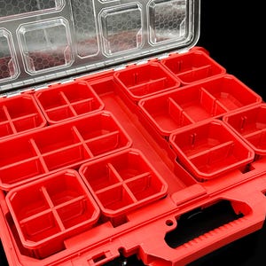 Könnte beinhalten: Ein roter, offener Werkzeugorganizer mit mehreren Fächern und einem transparenten Deckel. Der Organizer verfügt über verschiedene rote Behälter unterschiedlicher Größe zur Aufbewahrung von Kleinteilen und Werkzeugen. Der transparente Deckel ermöglicht eine einfache Sicht auf den Inhalt.
