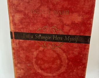 May include: A red hardcover book with the title "I'm a Stranger Here Myself" by Ogden Nash. The book has a gold design on the front cover.