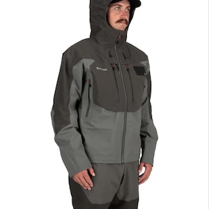 May include: A gray and dark gray waterproof fishing jacket with a hood and a black brim. The jacket has multiple pockets and a zipper closure. The brand name "Simms" is visible on the chest. The jacket is paired with matching gray pants.