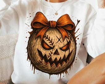 Może przedstawiać: Biała bluza z motywem Halloween. Projekt przedstawia dynię z pomarańczową kokardą, przeszytymi detalami i wściekłą twarzą. Brązowe plamy otaczają dynię, tworząc upiorną estetykę.