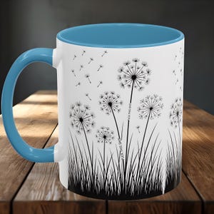 May include: White ceramic mug with a blue interior and handle. The mug features a black and white dandelion design with the text "FUCK THIS SHIT". The design includes dandelion seed heads and grass.