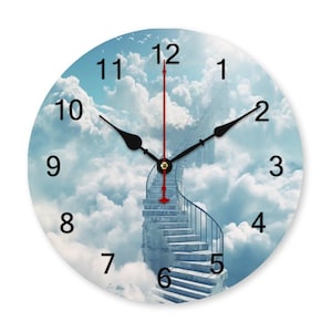 May include: Round wall clock with a sky-themed design. The clock face features a staircase leading into the clouds, with a blue sky and fluffy white clouds. Black clock hands and numbers are visible.