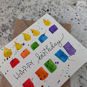 Cartão de feliz aniversário com vela arco-íris aquarela