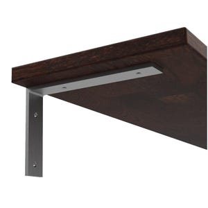 Può includere: Una mensola in legno marrone scuro con una staffa in metallo argentato. La mensola è rettangolare e presenta una venatura del legno visibile. La staffa è a forma di L ed è fissata sotto la mensola.