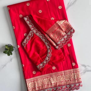 Pure Red banarasi pattu saree with moon & flower weaving on all over the saree. Scalloped lace attached on saree. Designer blouse available