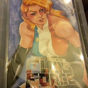 May include: A comic book cover featuring a blonde character with a determined expression, wearing a white, blue, and red outfit with black gloves. The title text reads F.C.KING AWESOME FLAG FORCE in bold white letters against a blue background.