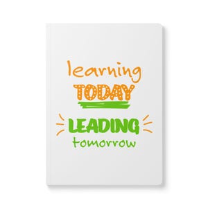 May include: White notebook with the text "learning today leading tomorrow" in orange and green lettering.
