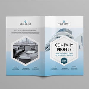 May include: An open brochure with a blue and white design. The text "YOUR BRAND" is at the top. The brochure displays a company profile with text and images, including a modern building and a living room scene.