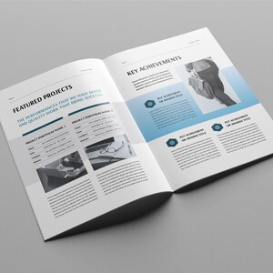 May include: Open brochure on a grey background. The brochure is open to two pages with text and images. The left page is titled "Featured Projects" and the right page is titled "Key Achievements". The brochure has a modern design with blue accents.