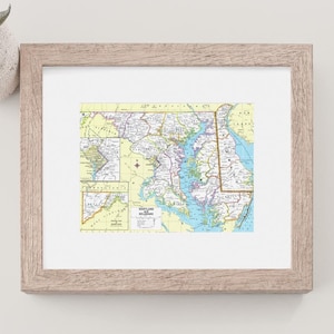 May include: A framed map of Maryland with a light brown frame. The map is in a vintage style and shows the state's major cities, roads, and waterways.