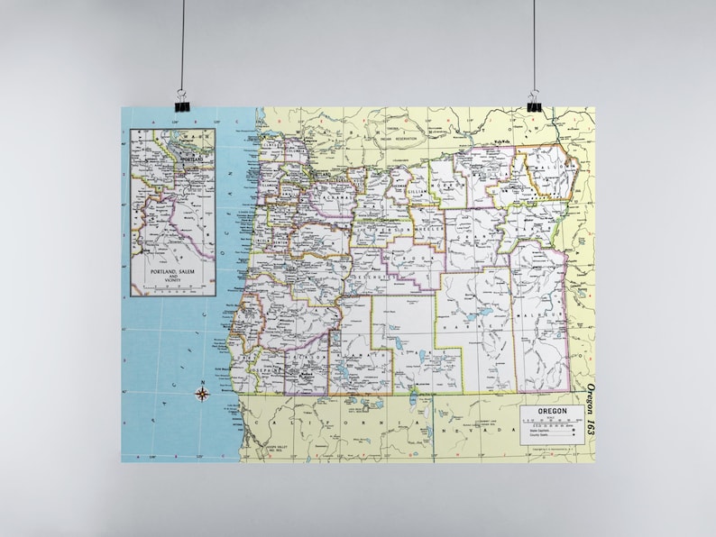 May include: A vintage map of Oregon, printed in yellow and green, with county borders outlined in black. The map includes a smaller inset map of the Portland area. The text "Oregon 163" appears in the bottom right corner.