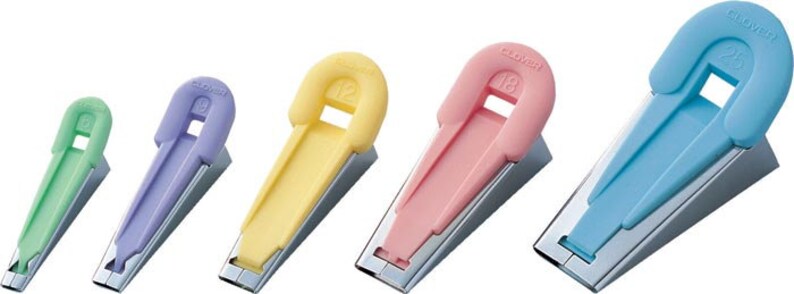May include: Set of five Clover brand seam rippers with different colored plastic handles. The handles are shaped like a loop with a number printed on them. The numbers are 1/8, 1/4, 1/2, 3/8, and 2/8.