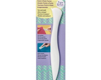 May include: White plastic tool for turning and marking fabric points and creases. The tool is labeled "Point 2 Point Turner" and has instructions in English, Spanish, French, and German. The packaging also includes the text "i sew for fun."