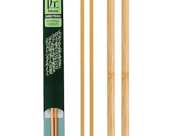 May include: A set of three pairs of Clover Takumi Bamboo Premium Knitting Needles. The needles are 13 inches long and are made of natural bamboo. The needles are packaged in a green and white cardboard box. The box has the Clover logo and the text "Takumi Bamboo Premium Knitting Needles" printed on it.