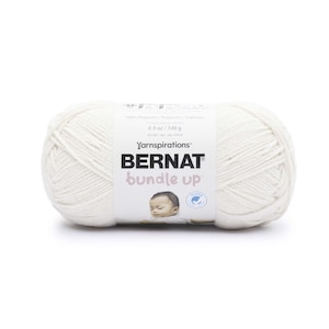 May include: A skein of off-white Bernat Bundle Up yarn. The label reads "100% Polyester" and "4.9 oz / 140 g". The yarn is a soft, textured material, ideal for knitting or crocheting baby blankets and other projects.