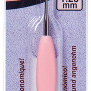 May include: Pink steel crochet hook with a black and silver handle. The hook is size 4, 1.25 mm. The packaging is green and purple with the text "Amour Steel Crochet Hook" and "No. 4 1.25 mm".