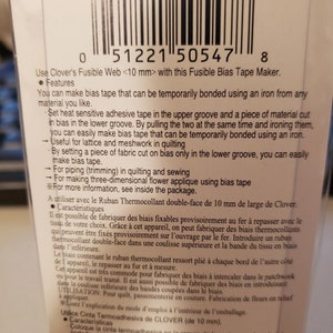 May include: Close-up of a white and black package with a barcode and product information. The package is for a Clover Fusible Bias Tape Maker. The text on the package reads: "Use Clover's Fusible Web <10 mm> with this Fusible Bias Tape Maker."