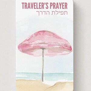 K&ouml;nnte beinhalten: Aquarellillustration einer Strandszene mit einem rosa Sonnenschirm, Sand und Meer. Der Text "TRAVELER'S PRAYER" steht oben, darunter hebr&auml;ische Schrift. Das Bild hat eine weiche, pastellfarbene Farbpalette.