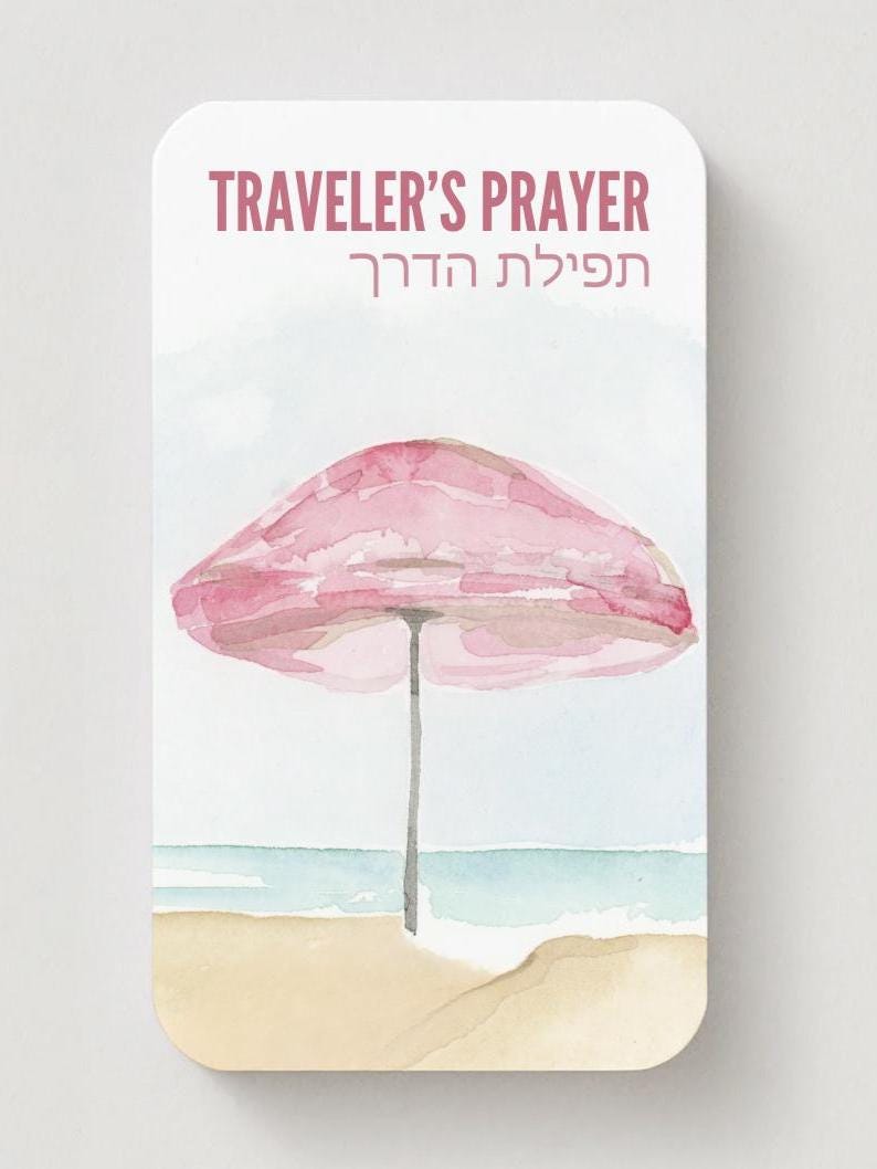 K&ouml;nnte beinhalten: Aquarellillustration einer Strandszene mit einem rosa Sonnenschirm, Sand und Meer. Der Text "TRAVELER'S PRAYER" steht oben, darunter hebr&auml;ische Schrift. Das Bild hat eine weiche, pastellfarbene Farbpalette.