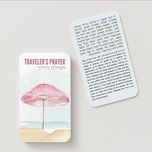 K&ouml;nnte beinhalten: Eine Karte im Aquarellstil mit dem Text "TRAVELER'S PRAYER" und hebr&auml;ischen Text. Die Karte zeigt einen rosa Sonnenschirm an einem Sandstrand mit blauem Ozean. Eine zweite Karte mit Text ist ebenfalls vorhanden.