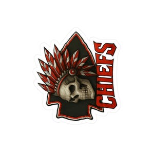 May include: A sticker featuring a skull wearing a Native American headdress, set against a black arrowhead shape. The headdress has red and white feathers. The word "CHIEFS" is printed in red.
