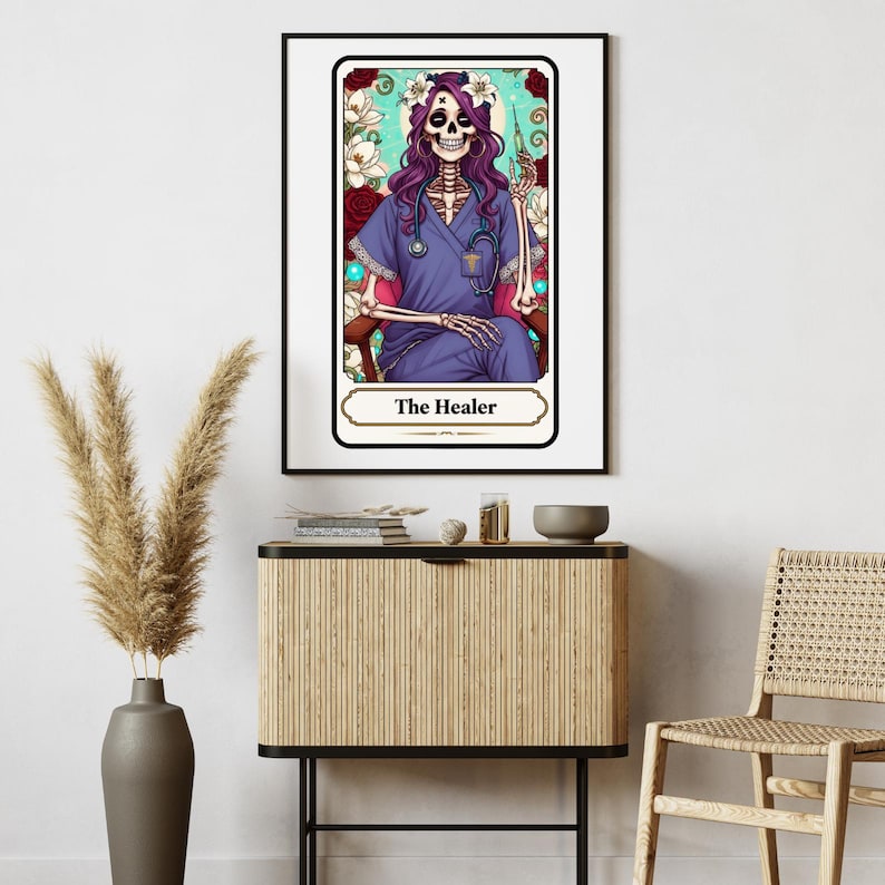 Puede incluir: Una impresi&oacute;n enmarcada que presenta un esqueleto con uniforme m&eacute;dico, un estetoscopio y una jeringa, etiquetada como "The Healer". La obra de arte tiene un fondo floral con una combinaci&oacute;n de colores turquesa y rojo. El esqueleto tiene pelo morado y una corona de flores.