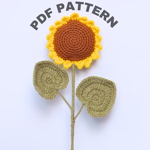 May include: A crocheted sunflower with a brown center and yellow petals. The sunflower has two green leaves and a brown stem. The image includes the text "PDF PATTERN".