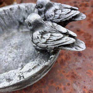 Handmade concreate bird bath. Garden bird feeder with sculpted birds. Rustic outdoor decor.