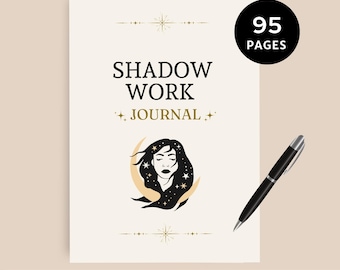 May include: A cream-colored journal with the words "SHADOW WORK JOURNAL" and an illustration of a woman's face with stars. A black pen with a silver tip rests on the right. The journal has 95 pages.